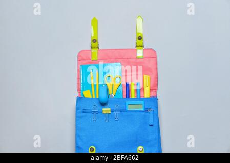 School backpack and stationery on grey background Stock Photo