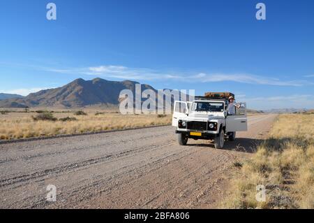 Road trip through the Namibian desert in a 4WD with a roof top tent. Adventure African holiday. Stock Photo