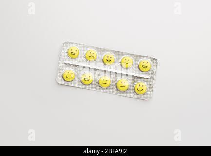 Blister pack and pills with different drawn faces on white background Stock Photo