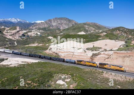 Freight train climbing the grade at Cajon Pass in San Bernardino County, part of the large logistics chain of Southern California Stock Photo