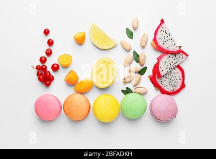 Tasty macarons with fruits and nuts on white background Stock Photo