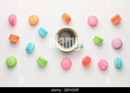 Tasty macarons with cup of coffee on white background Stock Photo