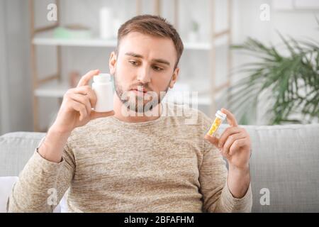 Young man with medicines at home Stock Photo