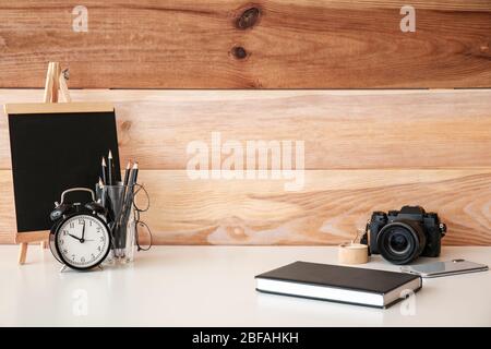 Modern stylish workplace of photographer near wooden wall Stock Photo