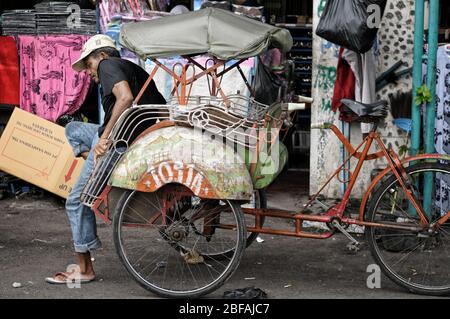 Driver and his cycle rickshaw in Yogyakarta, Java, Indonesia Stock Photo