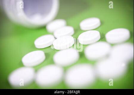 Aspirin tablets spilling from an open bottle Stock Photo