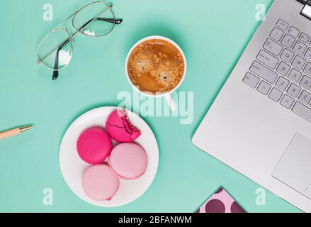 Laptop, macarons and cup of coffee flat lay. Stock Photo