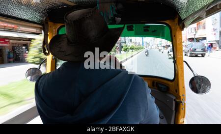 Point of view shot from inside a moving tuk tuk in Phnom Penh, Cambodia. Tuk Tuk or Remorque. Stock Photo