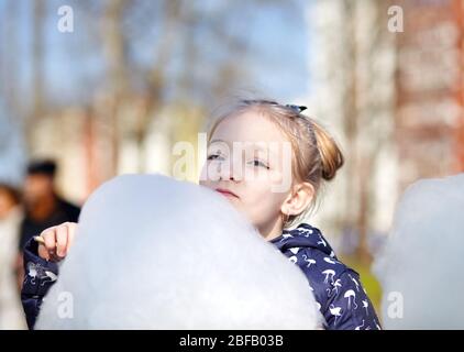 Cute little girl eating cotton candy. Happy childhood and children's emotions Stock Photo