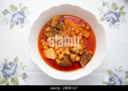 Kufta bozbash Middle Eastern mutton soup . Bowl of Bozbash - delicious Azerbaijan national soup on the table with white flowers . Stock Photo