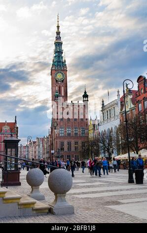 Gdansk, Poland, April 15, 2018: People walk down Dluga Long Market street Dlugi targ square in old historical town centre near City Hall with clock to Stock Photo