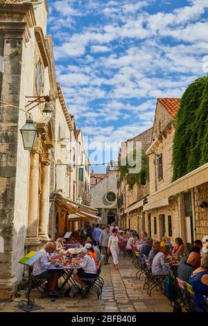 People dine outside in a pedestrian area in the Old Town of Dubrovnik, Croatia Stock Photo