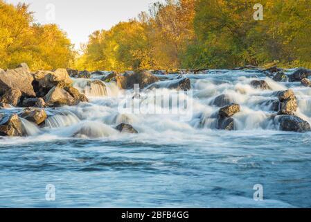waterfall lit by the setting sun over the Boise River in Boise, ID. Stock Photo