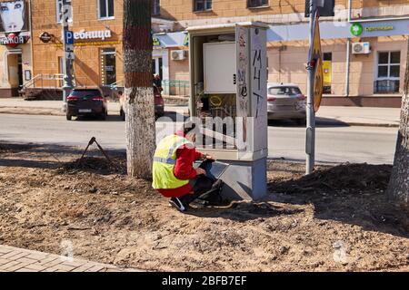 Perm, Russia - April 15, 2020: communications engineer is repairing something in a wired telecommunications network distribution cabinet on a deserted Stock Photo
