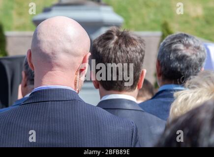 Secret service agent (security guard) with earpiece, behind view. Selective focus