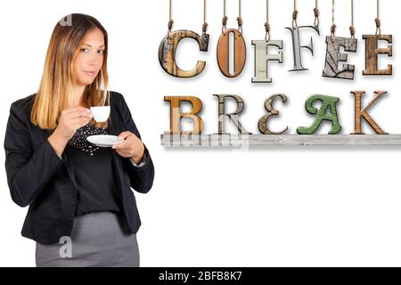 Woman drinking coffee with text coffee break hanging on white background. A woman is standing having a coffee. Stock Photo