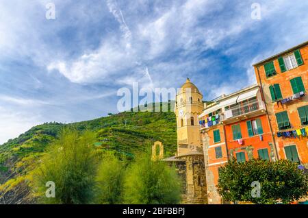 Chiesa di Santa Margherita di Antiochia church and colorful building in Vernazza village, blue sky with transparent white clouds background, National Stock Photo