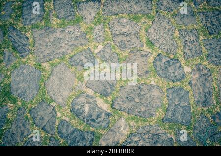 Cobblestone pavement background with copy space. Abstract old close-up cobble stone texture. Paving stone patterned street view from above, paving til Stock Photo
