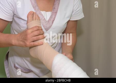 Lymphedema management: Wrapping leg using multilayer bandages to control Lymphedema. Part of complete decongestive therapy (cdt) and manual lymphatic Stock Photo