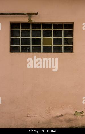 Facade of an old building with metal windows and rungs Goal bar roller door Stock Photo