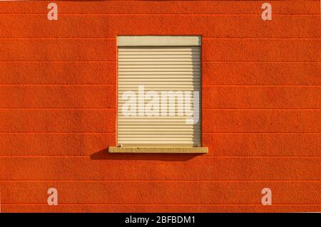 Facade with bright red colors a window blinds centered horizontal line pattern Stock Photo