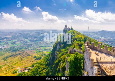 Republic San Marino Seconda Torre La Cesta second fortress tower with brick walls on Mount Titano stone rock, green trees, aerial top panoramic view o Stock Photo