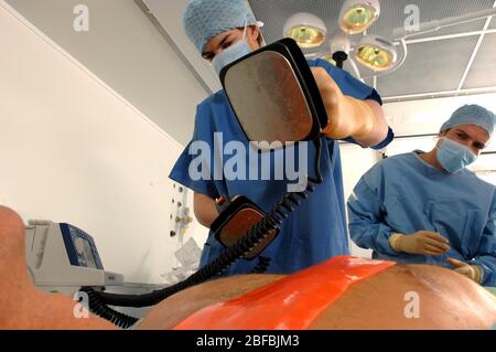 Doctors using a defibrillator to resuscitate a male heart attack victim Stock Photo