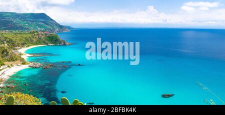 Aerial amazing tropical panoramic view of turquoise gulf bay, sandy beach, green mountains and plants, blue sky white clouds background, cliffs platfo Stock Photo