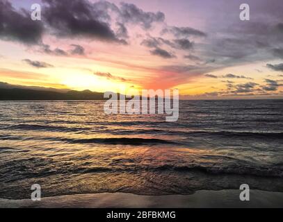 Sunset with some clouds at Las Canteras beach in Las Palmas de Gran Canaria. Stock Photo