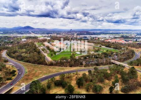 The capital hill in Canberra with Federal parliament house overlooking lake Burley Griffin in scenic aerial view. Stock Photo