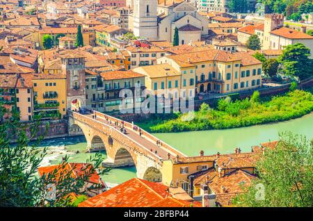 The Ponte Pietra Stone Bridge, Pons Marmoreus, Roman arch bridge across Adige River, buildings with red tiled roofs in Verona historical city centre, Stock Photo
