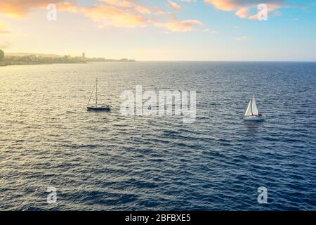 Two sailboats just outside the harbor and city walls of the ancient city of Valletta Malta, and island in the Mediterranean Sea. Stock Photo