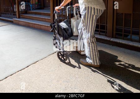 Senior woman walking with wheeled walker Stock Photo - Alamy