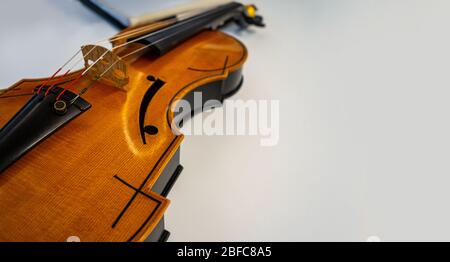 wooden violin  classical stringed instrument placed down on white table Stock Photo