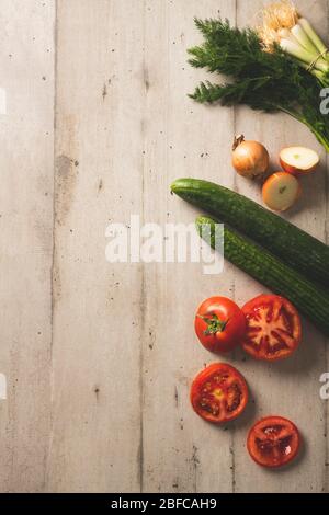 Fresh cucumbers, tomatoes onions and dill on a light color wooden background Stock Photo