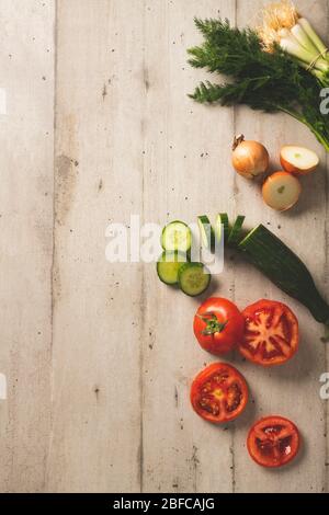 Slices of tomatoes and cucumbers with fresh onions and dill on a wooden background Stock Photo
