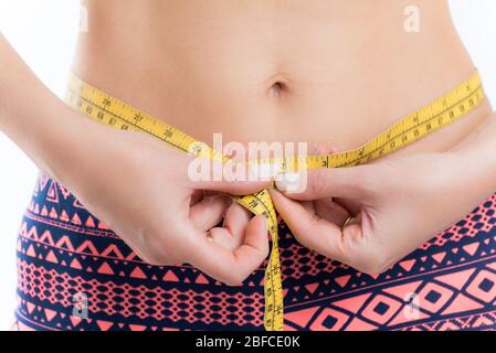 Woman measuring her waist with centimeter tape at home Stock Photo - Alamy