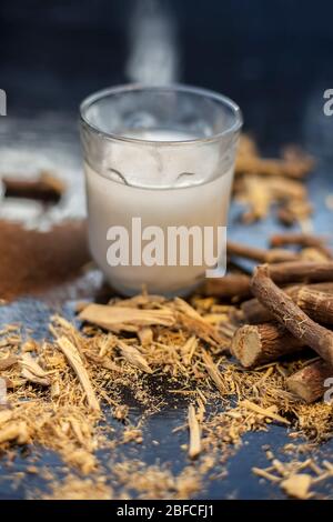 Milk Face Pack For Clear Complexion On Shiny Black Wooden Surface Ie Raw  Milk Well Mixed With Sandalwood Powder In A Glass Bowl And Entire Raw  Ingredients On The Surface Stock Photo -