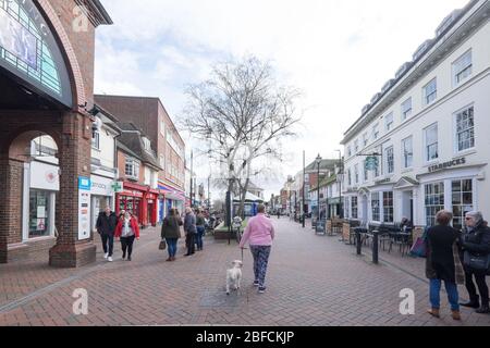 Ashford, Kent, United Kingdom - March 9, 2020: People walking and chatting on High Street in the pedestrianised town centre with shops Stock Photo