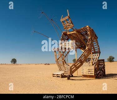 The sculpture of Man planting the flower, built of wooden pallets. Symbol of the desert transformation in Southern Israel. Kibbutz Gevulot, Gaza Strip Stock Photo