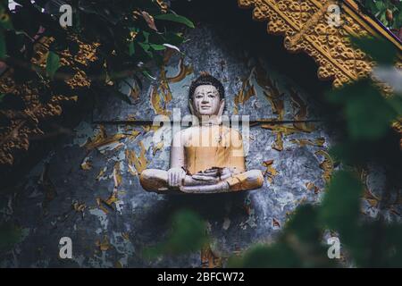 Cinematic photo of an old buddha sculpture in khmer style on an abandoned temple in Bokor Mountains in Kampot Province, Cambodia Stock Photo