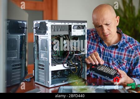 Computer repair. Computer technician working on a personal computer. Stock Photo