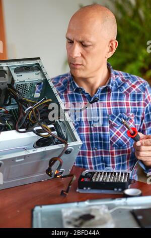 Engineer performing laptop maintenance. Hardware developer fixing electronic components. PC technology Stock Photo