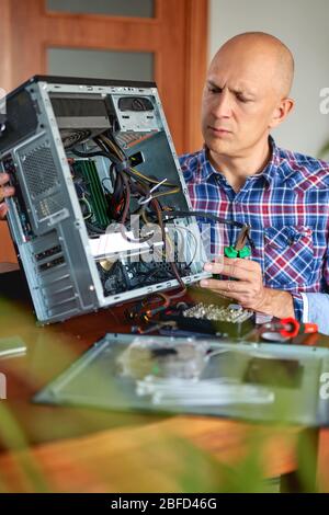 Engineer performing laptop maintenance. Hardware developer fixing electronic components. PC technology Stock Photo