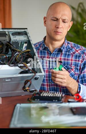 Computer repair. Computer technician working on a personal computer. Stock Photo