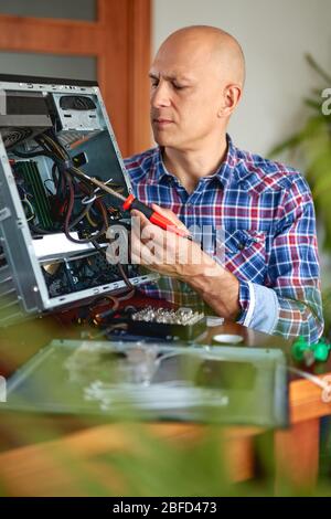 Computer engineer working on broken console at home Stock Photo