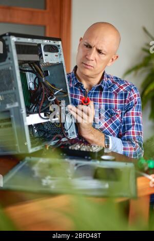 Computer engineer working on broken console at home Stock Photo