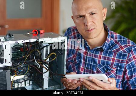 Computer repair. Computer technician working on a personal computer. Stock Photo