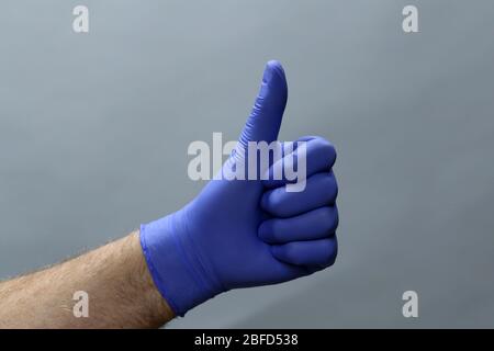 Hand in surgical latex glove gesture thumbs up good Stock Photo