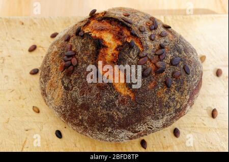 A freshly cooked loaf of bread with pumpkin sees on top Stock Photo